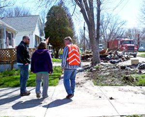 The Rev. Jacob Ehrhard (left), Tammy Fechner and Lutheran Early Response Team volunteer Andy Radetski talk among flood debris in Marseilles, Ill. (Lutheran Church Charities)