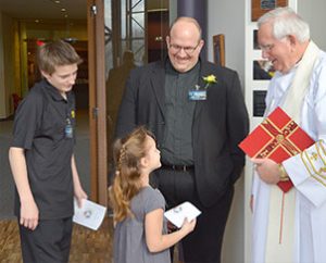 Newly installed director of Rural and Small Town Mission, Rev. Todd Kollbaum (second from right) and two of his children, Ryan and Emily, visit with LCMS Missouri District President Rev. Ray Mirly. (LCMS Communications/Frank Kohn)