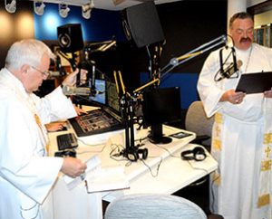 KFUO Director of Broadcast Services Rev. Rodney Zwonitzer, left, and LCMS President Rev. Dr. Matthew C. Harrison offer prayers and thanks during the June 24 dedication and blessing of the new KFUO studios at the LCMS International Center in St. Louis. (KFUO/Gary Duncan)