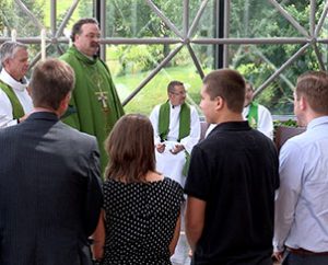 During the June 14 'sending service,' new LCMS missionaries and their family members (foreground) receive congratulations from (left to right) the Rev. Dr. Edward Grimenstein, director of LCMS Missionary Services; the Rev. Randy Golter, executive director of the LCMS Office of International Mission; and LCMS President Rev. Dr. Matthew C. Harrison. (LCMS Communications)