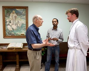 Vicar Aaron Uphoff, right, talks with Trinity Lutheran Church, Norman, Okla., prayer service attendees on May 22. (Dan Gill)