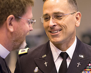 U.S. Army Chaplain Jonathan Shaw talks with the Rev. Tom Olson before Shaw addresses delegates about a resolution supporting religious and moral objections to women serving in ground combat.