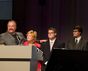 LCMS President Rev. Dr. Matthew C. Harrison, left, introduces his wife, Kathy, and the couple’s sons, Matthew, left, and Mark, at the 65th Regular Convention of The Lutheran Church—Missouri Synod.