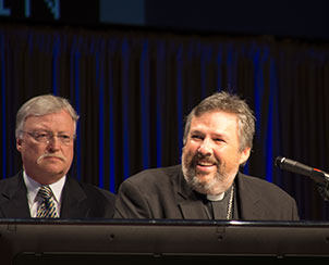LCMS New England District President Rev. Timothy Yeadon addresses the convention July 21. Even though the district had a "tough year" in the aftermath of Superstorm Sandy, the Newtown shootings and the Boston Marathon bombings, Yeadon said "Satan has failed to divide us from one another, and we will never be divided from Jesus, and we will never be divided from each other." At left is the Rev. Donald Fondow, chairman of Floor Committee 3 on Life Together. (LCMS Communications)