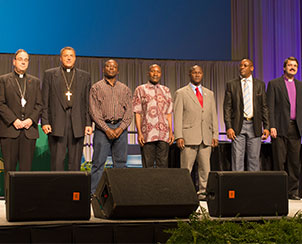 The convention recognizes visiting international Lutheran church leaders, from left, Rev. Dr. Robert Bugbee, Rev. Gennadij Khonin, Rev. Amos Bolay, Rev. Samuel S.Y. Navoh, Rev. James Kollie, Archbishop Christian Ekong and Bishop Vsevolod Lytkin. (LCMS Communications)