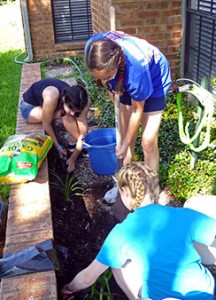 Three young people from Luther Memorial Lutheran Church in Tinton Falls, N.J., work in a resident’s garden during a servant event at Patriot Heights Senior Living facility in San Antonio during the 2013 National LCMS Youth Gathering. (LCMS Communications/Megan Mertz) 