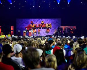 Concordia University, Nebraska, Seward, students give a shout-out to their school from the stage of the Alamodome in San Antonio before the July 1 opening night Mass Event that kicked off the 2013 National LCMS Youth Gathering. (Annie Sparks)