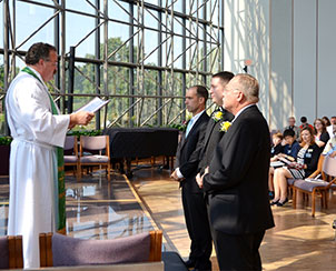 Synod President Rev. Dr. Matthew C. Harrison, left, installs three new staff members during the Aug. 19 chapel service at the LCMS International Center in St. Louis.  Left to right, they are Mark Cannon, senior vice-president for Finance and Administration for the LCMS Foundation; the Rev. Michael Meyer, manager of Distaster Response for the LCMS; and Terry L. Schmidt, the LCMS director of School Ministry. (LCMS Communications/Frank Kohn)