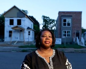 Carolyn Conner of St. Louis stands between her new home, left, still under construction, and the model home, right, in Lutheran Housing Support’s newest development, Nazareth Homes in the College Hill area of St. Louis. Conner will become the development’s first home buyer this fall. In all, the development will have 20 homes. (LCMS Communications/Dan Gill)