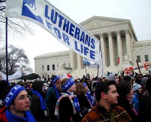Members of the Lutherans For Life delegation, wearing matching blue-and-white headbands and scarves, carry their banner high as they pass the U.S. Supreme Court building during the 2007 "March for Life" in Washington, D.C. (LCMS Communications/Paula Schlueter Ross)