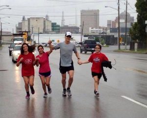 The family of the Rev. Mark Junkans, executive director of LINC Houston, runs alongside him during the last leg of his 24-hour "Run 4 the City" fundraiser that netted more than $80,000 for mission work. On the far left and right are daughters Victoria and Jessica, and second from left is Junkans' wife, Natalia. (LINC Houston)