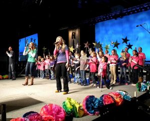 Students from Divine Redeemer Lutheran School, Hartland, Wis., sing with the group AriSon during a plenary session at the 11th Lutheran Education Association convocation in Milwaukee. Other groups from Lutheran schools also performed, including from three LCMS universities. (LCMS Communications/Joe Isenhower Jr.)