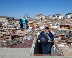 On Monday, Nov. 18, Randy Goldammer carries his desktop computer out of the basement where he and his family rode out the Nov. 17 tornado in Washington, Ill. (LCMS Communications/Dan Gill)