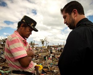 The Rev. Ross Johnson, right, co-director of LCMS Disaster Response, prays with resident John Lajara amid typhoon debris in Tacloban, the Philippines, on Nov. 19. Johnson and other Synod disaster staff brought relief supplies to residents and "prayed with them, spent time with them," Johnson said. "It was absolutely overwhelming." (LCMS Communications/Erik M. Lunsford)