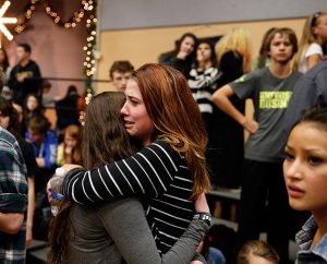 Freshman Allie Zadrow, center-right, hugs classmate Liz Reinhardt at Shepherd of the Hills Lutheran Church after a shooting at nearby Arapahoe High School in Centennial, Colo., on Dec. 13. The LCMS church, located one block from the high school, became a safe haven for about 1,800 terrified students who were evacuated after shots rang through the school. (AP Photo/Brennan Linsley)