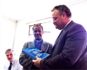 In Ethiopia, LCMS President Rev. Dr. Matthew C. Harrison, right, receives a book on the history of the Mekane Yesus Seminary of the Ethiopian Evangelical Church Mekane Yesus (EECMY) from EECMY  President Rev. Dr. Wakseyoum Idosa. At left is LCMS missionary Rev. Dr. Carl Rockrohr, dean of the School of Theology at the seminary. (Albert B. Collver III)