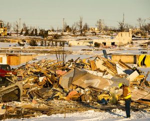 Workers gather near the rubble of a home in a damaged neighborhood of Washington, Ill., on Dec. 18, 2013. Nearly two dozen tornadoes plowed through Illinois in November, killing a total of seven people. (LCMS Communications/Erik M. Lunsford)