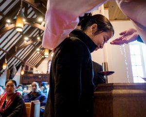 The Rev. Matthew Clark baptizes Bema Gurung, one of 21 Nepali immigrants he baptized Jan. 12 at Ascension Lutheran Church, St. Louis. (LCMS Communications/Erik M. Lunsford)