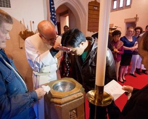 The Rev. Matthew Clark baptizes Nepali immigrant Rana Tamang at Ascension Lutheran Church. “It’s not always comfortable, but it’s a blessing,” Clark said about the congregation’s work with the Nepalese community. (LCMS Communications/Erik M. Lunsford)