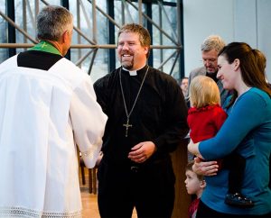 The Rev. Randall Golter, executive director of the LCMS Office of International Mission, congratulates the Rev. Micah and Robin Wildauer during the Rite of Sending for missionaries on Feb. 14, 2014. (LCMS Communications/Erik M. Lunsford)