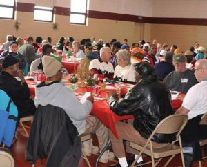 Residents from the neighborhoods around St. Paul Lutheran Church, Cincinnati, enjoy a Christmas dinner in the church’s renovated gym. The congregation led by then-Pastor Rev. Steve Schave held the dinner so no one would be alone or in need on Christmas Day. (St. Paul Lutheran Church) 