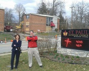 Deaconess Sara Smith and the Rev. Steve Schave stand proud on the lawn of St. Paul Lutheran Church, Cincinnati — where they served at the time —on the day demolition began for the apartment complex known as the “Devil’s Playground.”  That day came to represent a revitalization for the neighborhood. (St. Paul Lutheran Church circa 2012)