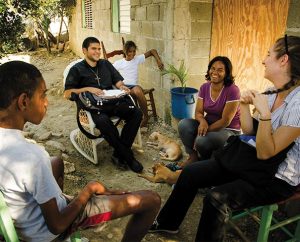 Vicar Gustavo Arturo Maita (second from left), a student from Concordia Seminary Argentina and a member of the Lutheran Church of Venezuela, conducts one of his regular visits with village residents in Palmar Arriba, Dominican Republic. (LCMS Communications/Pamela Nielsen)