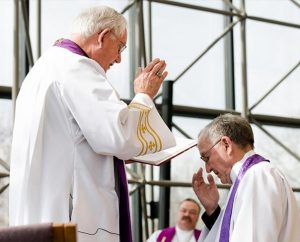 LCMS Missouri District President Rev. Dr. Ray Mirly, left, installs the Rev. Dr. Dean O. Wenthe as president of the Concordia University System (CUS) at the LCMS International Center on March 31 — the same day as a CUS think-tank meeting there. Synod President Rev. Dr. Matthew C. Harrison, center, delivered the sermon for the installation service. (LCMS Communications/Erik M. Lunsford)