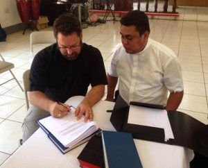 The Rev. Dr. Albert B. Collver III, director of LCMS Church Relations and Regional Operations, left, and Lutheran Church—Synod of Nicaragua President Rev. Marvin Donaire sign a protocol agreement May 13 in Chinandega, Nicaragua. Also signing the document, which allows for expansion of mission work in that country, was the Rev. Leonardo Neitzel, a representative of Lutheran Church—Canada. (LCMS Church Relations)