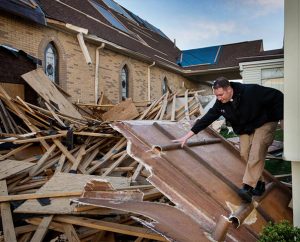 The Rev. Michael Meyer, manager of LCMS Disaster Response, climbs through debris May 1 at Holy Trinity Lutheran Church in Tupelo, Miss. The storm blew off part of the church’s roof, tore off its steeple and blew out several windows. (LCMS Communications/Erik M. Lunsford)
