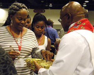 Worshipers receive Holy Communion during the July 9 opening service of the Black Ministry Family Convocation in Kansas City, Mo. More than 460 people took part in the five-day convocation, which focused on witness and outreach. (LCMS/Paula Schlueter Ross)