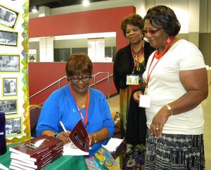 Mary Jones Wise, a great-niece of famed Lutheran educator Rosa J. Young, signs a copy of Young's autobiography, Light in the Dark Belt, during the Black Ministry Family Convocation in Kansas City. A film documentary about Young, "The First Rosa: Teacher, Confessor, Church Planter," is in the works, with a release planned for February. (LCMS/Paula Schlueter Ross)