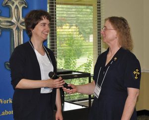 After four years as president of Concordia Deaconess Conference (CDC), Cheryl D. Naumann, right, of Oakmont, Pa., hands the microphone over to newly elected President Jennifer M. Phillips of Monroeville, Ind., during the CDC’s annual conference June 23-25 in Winter Park, Fla. (Sara Smith)