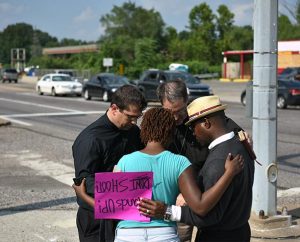 The Rev. Ross Johnson, director of LCMS Disaster Response, and the Rev. Steven Schave, director of LCMS Urban & Inner-City Mission, pray with people along West Florissant Avenue in Ferguson, Mo., on Aug. 18. (LCMS/Erik M. Lunsford)