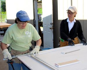 From left, Laborers Kim Heaps of Redding, Calif., and Phyllis Bockelmann, Dow City, Iowa, cut sheet rock as part of the renovation and energy-efficiency project at Trinity Lutheran School, Portland, Ore. The congregation is participating in Lutheran Church Extension Fund’s Laborers For Christ to make the improvements. (Lisa Noreen) 