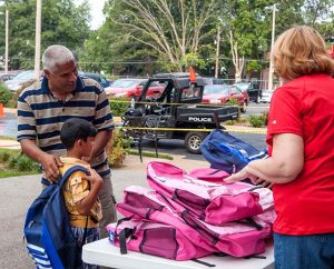 A young student tries on his backpack filled with school supplies and a Bible-story book, courtesy of Concordia Publishing House's "Operation F.U.N." (For a United Neighborhood), held Aug. 6 on the publisher's parking lot in St. Louis. (Concordia Publishing House)