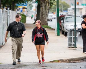 The Rev. Steven Schave, director of Urban Ministry for the Synod, and Darrian Doederlein of Lamesa, Texas, chat as they conduct “Gospel Seeds” canvassing near Shepherd of the City Lutheran Church in Philadelphia as part of the Lutheran Youth Corps pilot project. (LCMS/Erik M. Lunsford)