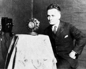 The Rev. Dr. Walter A. Maier, the station's first "Gospel voice," poses with a microphone from that early era.