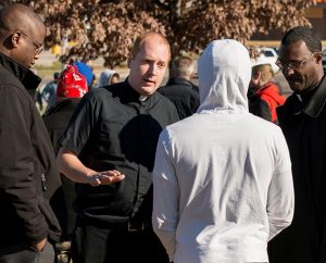 From left, Vicar Chris Chandler, the Rev. Adam Filipek and the Rev. John Lewis talk to a protester in Ferguson, Mo., on Nov. 25. Synod leaders are making a plan to open a permanent ministry in Ferguson to "rebuild hope and trust." (LCMS/Erik M. Lunsford)