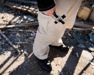 The Rev. Steven Schave, director of LCMS Urban & Inner-City Ministry, carries a cross as he surveys the remnants of the Family Dollar store on Halls Ferry Road in St. Louis on Nov. 25. The building caught fire the previous night following a grand jury decision not to indict Ferguson Police Officer Darren Wilson in the shooting death of Michael Brown. (LCMS/Erik M. Lunsford)