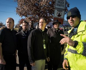 From left, the Rev. Adam Filipek, the Rev. Ross Johnson, the Rev. John Lewis, the Rev. Steven Schave and the Rev. Dr. Willie Stallworth talk to a state trooper in Ferguson, Mo., on Nov. 25. (LCMS/Erik M. Lunsford) 