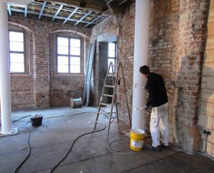 A painter applies fire-retardant paint to a support post in the room that will become a chapel and lecture hall. The chapel, which will be the largest room in the Old Latin School, will seat about 55 people. (David L. Mahsman)