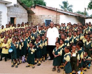 The Rev. Philip Saywrayne, pastor of Christ Assembly Lutheran Church in Staten Island, N.Y., poses with students at the Lutheran school he founded in Monrovia, Liberia, in 2006. Saywrayne's idea to help people in Liberia cope with the Ebola crisis resulted in a partnership that's providing $100,000 in food and other aid. (Courtesy of Philip Saywrayne) 