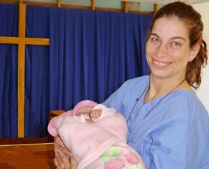 Carrie Collins holds a baby during a 2007 medical mission trip to Mexico. A $3,000 scholarship is being offered in memory of Collins, who died in 2008, to enable a nursing student to serve on a short-term Mercy Medical Team in 2015. (Courtesy Carolyn Smith)