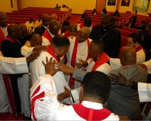 Pastors lay hands of blessing on LCMS Director of Black Ministry Rev. Roosevelt Gray Jr. (center, at left) during the Communion service at the LCMS Black Clergy Caucus gathering Jan. 14-16 in Dallas. (LCMS/Joe Isenhower Jr.)