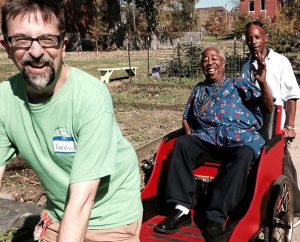 The Rev. David McBurney, senior pastor of Abiding Savior Lutheran Church in south St. Louis County, gives Otis Woodard a rickshaw ride during an Oct. 25 servant event at Lutheran North St. Louis Outreach. Woodard "personified the phrase 'servant leader,' " McBurney told Reporter, and "looked for opportunities to share the Gospel in word and deed." In the background is Abiding Savior sexton John Jones, who grew up in North St. Louis. (Joe Sell)