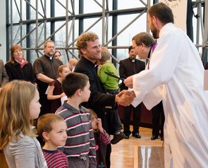 Christian Boehlke, right, director of LCMS Missionary Services, and the Rev. Dr. Herbert C. Mueller Jr., LCMS first vice-president, congratulate new missionary Rev. David Preus and his family during the March 13 "Sending Service." Preus, his wife, Jennifer, and six children are from Billings, Mont., and will be relocating to the Dominican Republic. (LCMS/Frank Kohn)