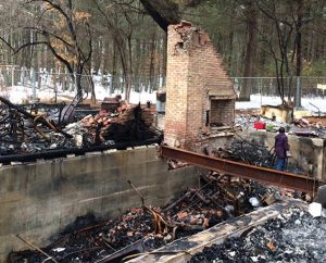 Daria Dutzmann inspects what's left of the family's home after the devastating explosion and fire. In spite of their losses, the family has been "blessed" by the love and care of many, according to the Rev. Ingo Dutzmann. (Courtesy of the Dutzmann family)