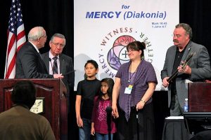 Retiring South Dakota District President Rev. Dr. Dale L. Sattgast, left, presents a gift to former LCMS missionary Amy Kashenov, second from right, to thank her for her service to Kazakhstan on behalf of the district. The work of Kashenov, who is now retired, was supported by the district for nearly 20 years. Also in the photo are, from left, the Rev. Dr. Ray Hartwig, LCMS secretary and Kashenov's father; Kashenov's children, Amanzhol and Kuralai; and Synod President Rev. Dr. Matthew C. Harrison. (South Dakota District)