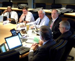 Synod Secretary Rev. Dr. Raymond Hartwig, foreground, provides a comment during the May 15-16 LCMS Board of Directors meeting. To Hartwig’s right are Board Chairman Rev. Dr. Michael Kumm, Synod Chief Administrative Officer Ron Schultz, and Board members Warren Puck, Ed Everts and the Rev. Dr. Victor Belton. (LCMS/Joe Isenhower Jr.)